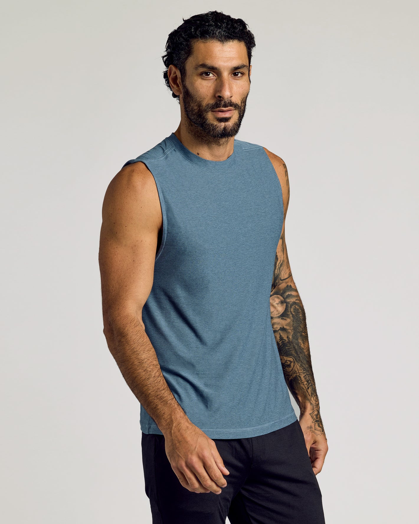 Man in Baltic Sleeveless Active Muscle Tee, showcasing athletic fit and tattoos.