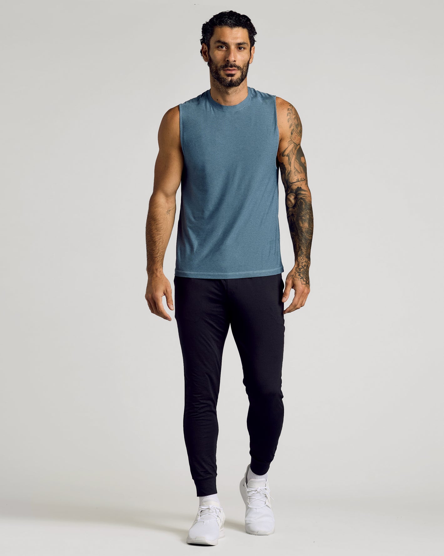 Man wearing Baltic Sleeveless Active Muscle Tee, showcasing athletic fit and tattoos.