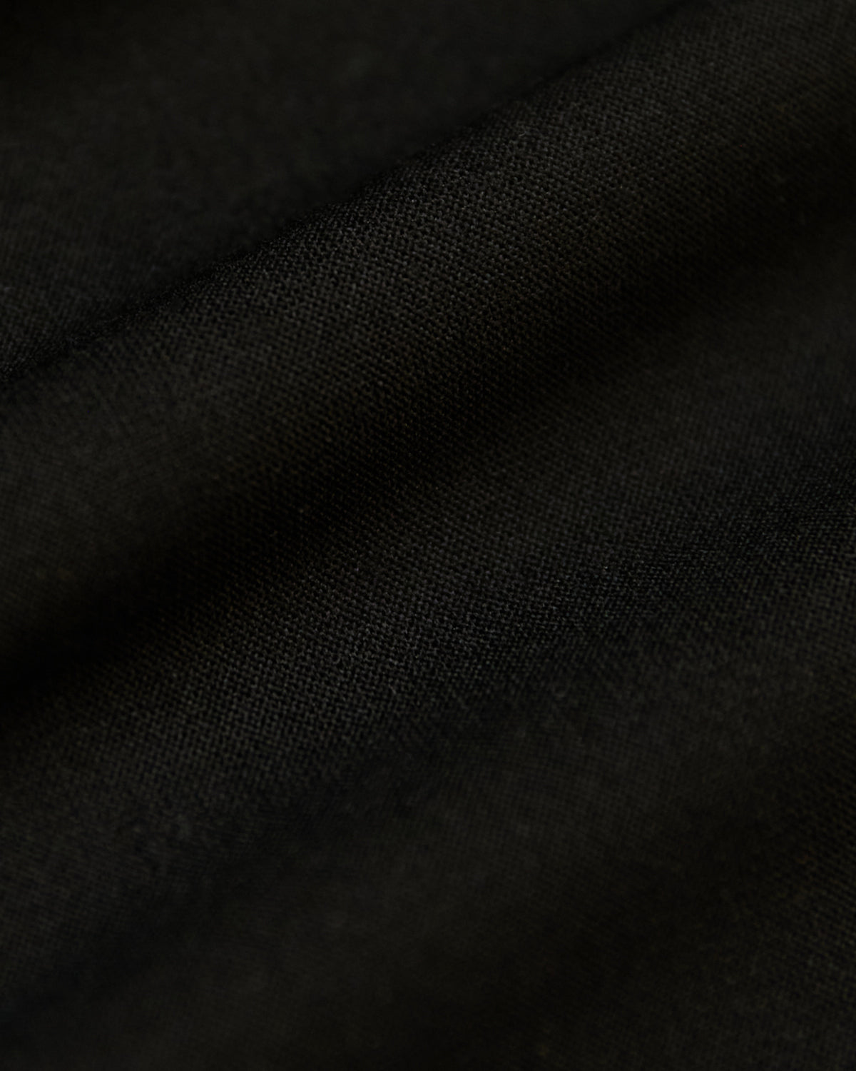 Black Active Sleeveless Muscle Tee with woven texture and gentle fabric folds.