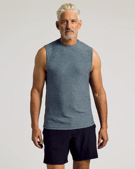 Man wears Heather Navy Sleeveless Active Muscle Tee, showcasing its relaxed fit.