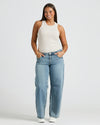 Woman in Womens Oatmeal Ribbed High Neck Tank and light jeans.