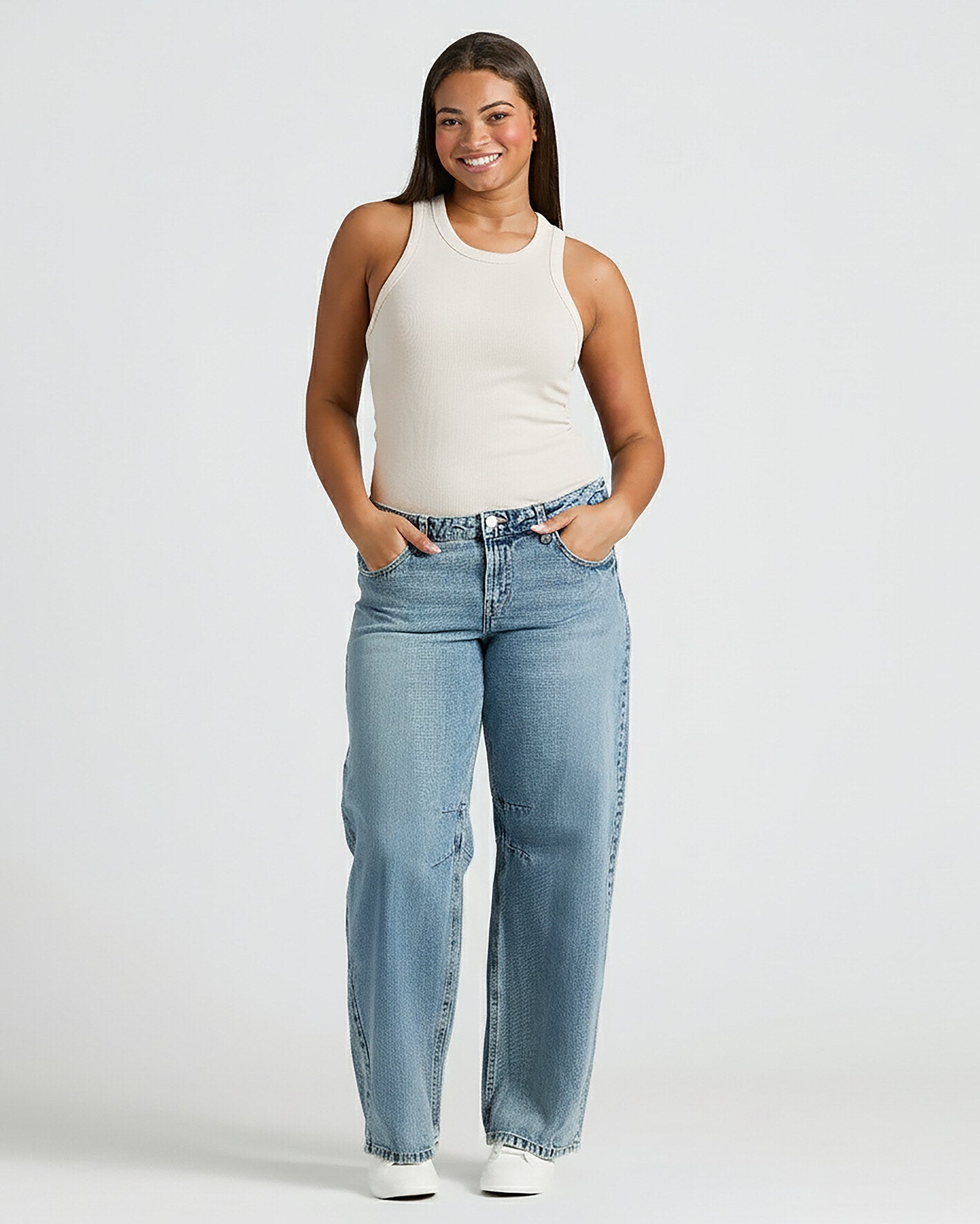 Woman in Womens Oatmeal Ribbed High Neck Tank and light jeans.