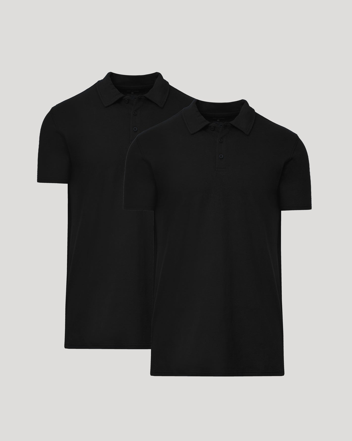 Two black polo shirts on a light gray background
