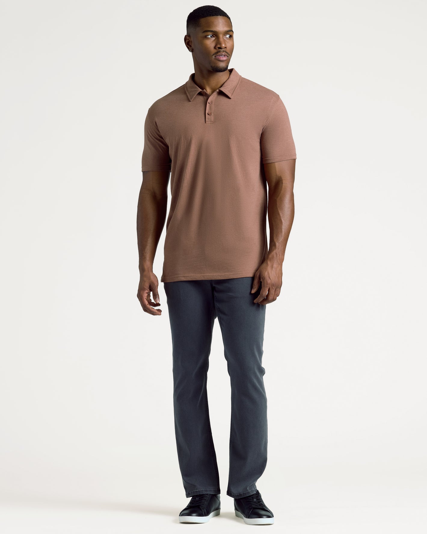Model wearing Dark Heather Sepia Short Sleeve Tall Polo and grayish-blue pants.