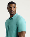 Young man modeling Light Heather Greenery Short Sleeve Tall Polo.