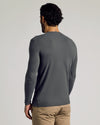 Man wearing Carbon Tall Classic Long Sleeve Henley and tan pants, back view.