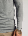 Heather Gray Tall Classic Long Sleeve Henley tucked over pants.
