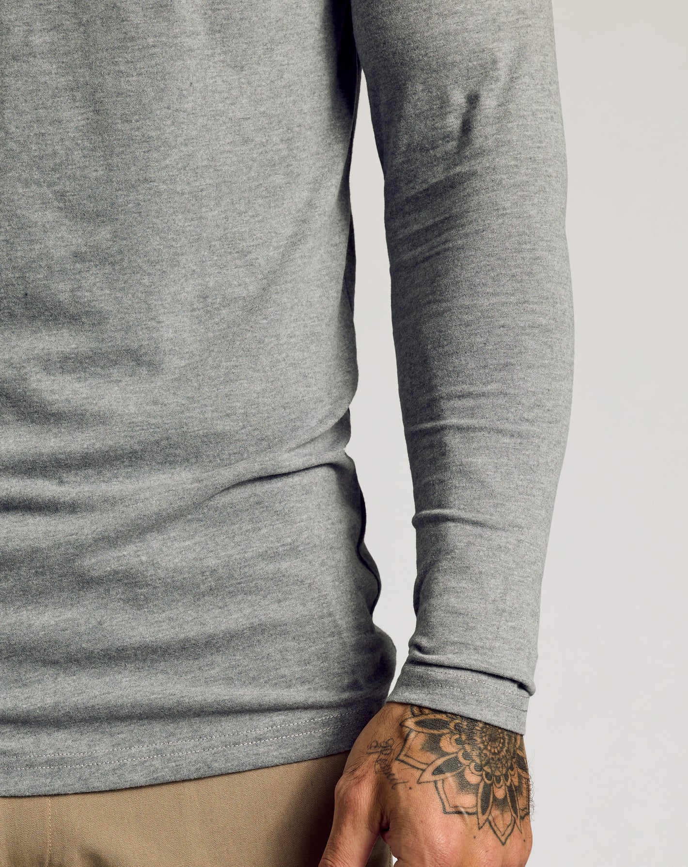 Heather Gray Tall Classic Long Sleeve Henley tucked over pants.