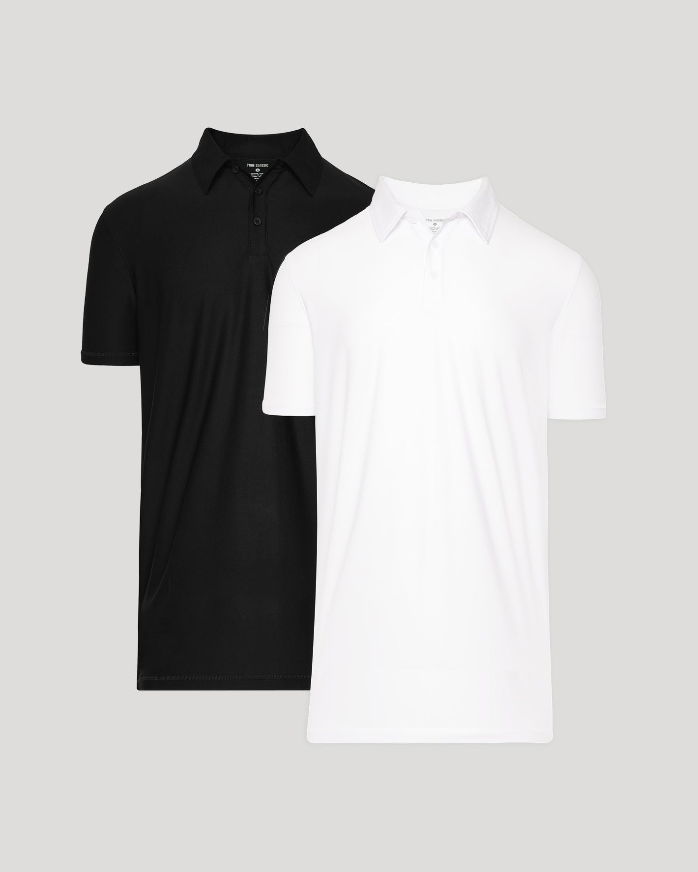 Black and white polo shirts stacked on a light gray background