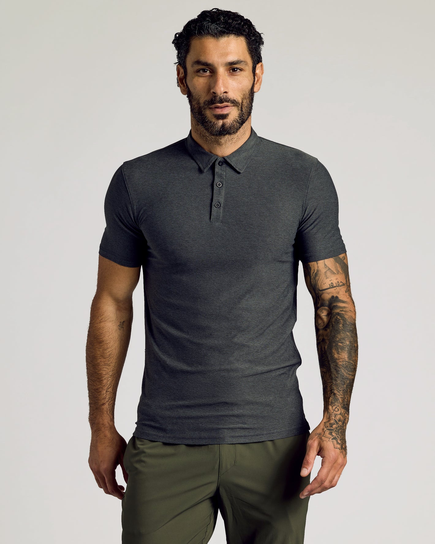 Man wearing Timeless Tall Active Polo, showcasing fitted style and tattooed forearm.