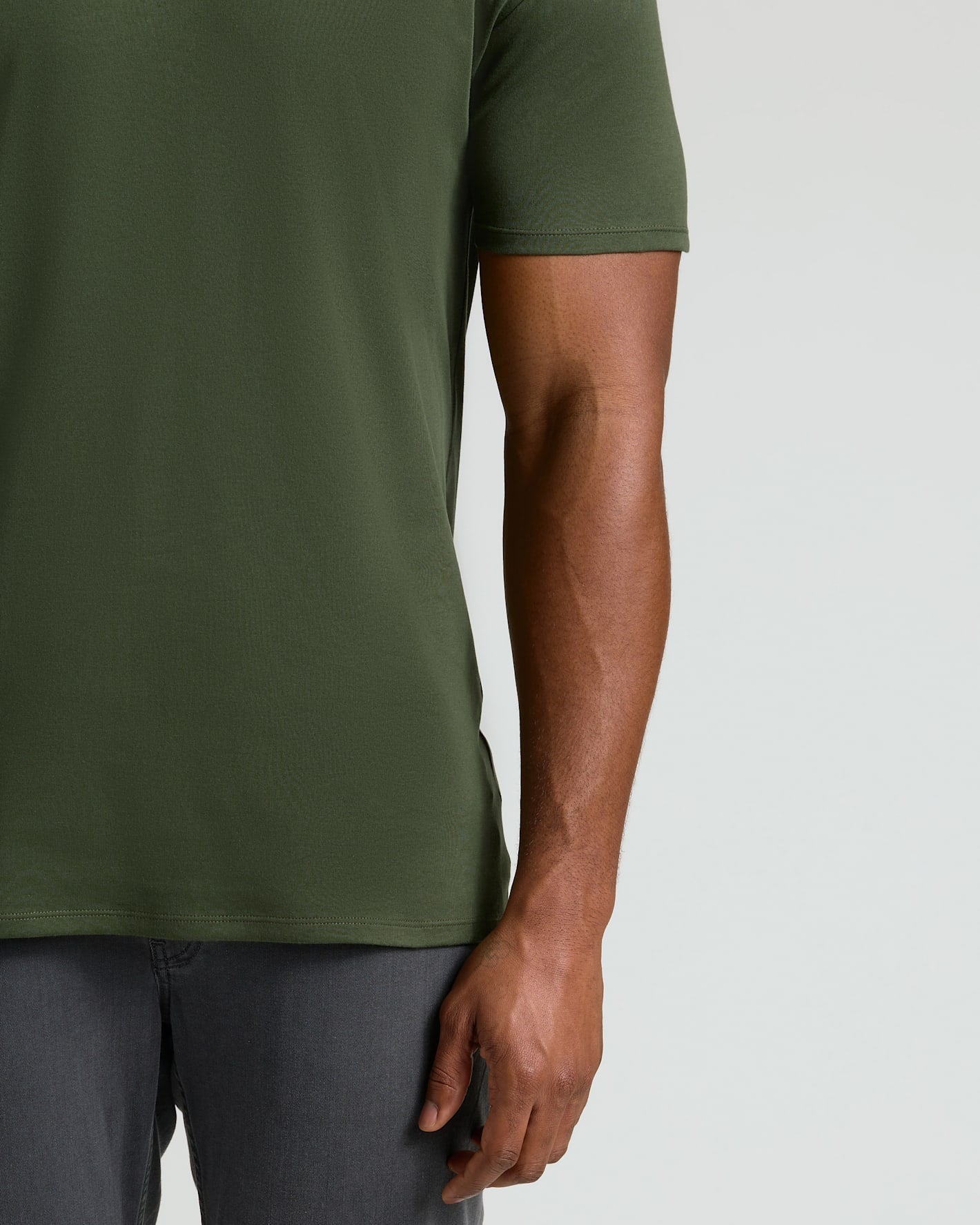 Close-up of a man's torso wearing an olive green Grove Tall Pima Cotton Blend Crew, paired with dark gray pants, highlighting the soft cotton blend fabric.