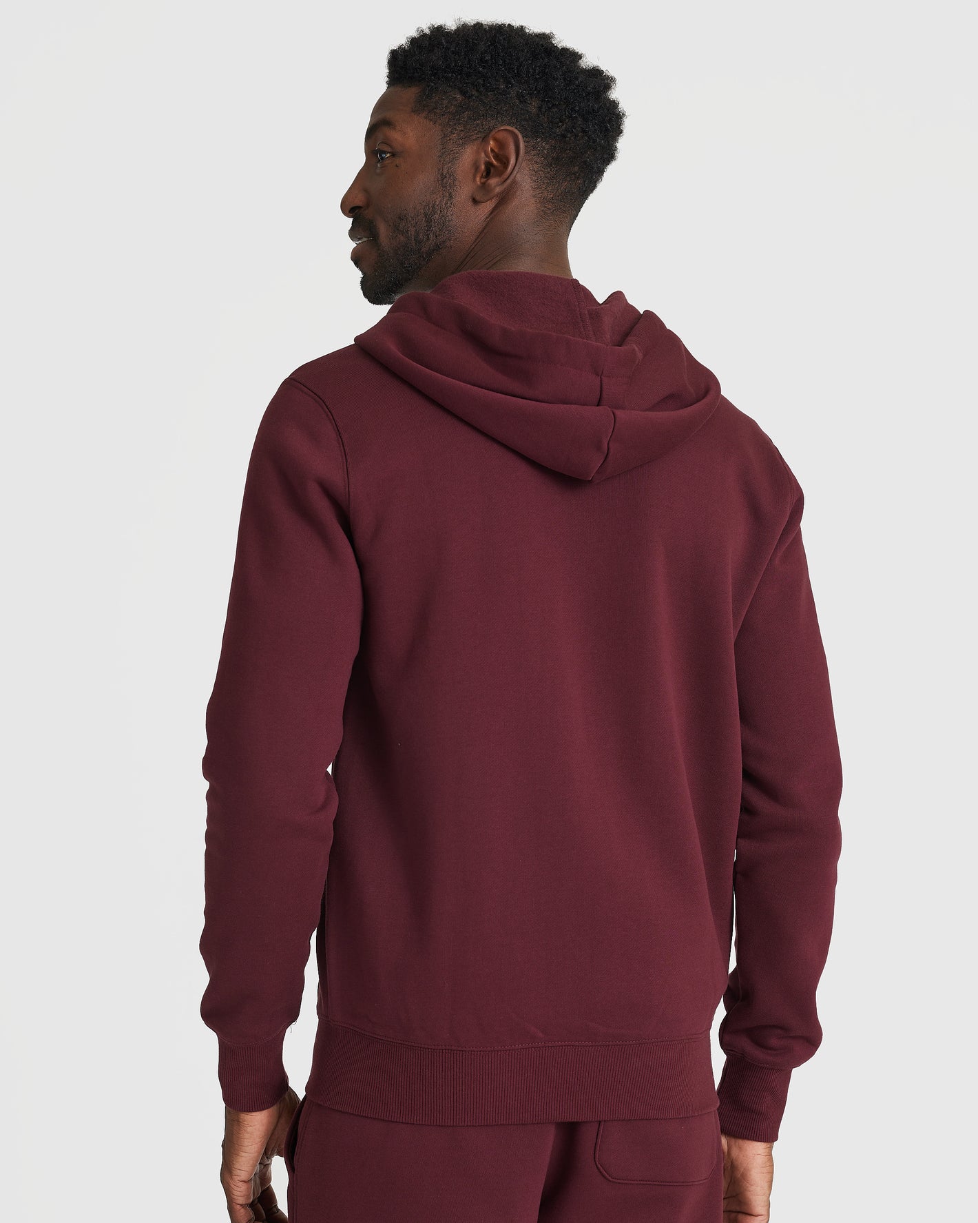Man in Mahogany Fleece French Terry Zip Hoodie, hood down.