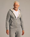 Model in 3 Day Travel Pack: light-gray zip-up hoodie, sweatpants.