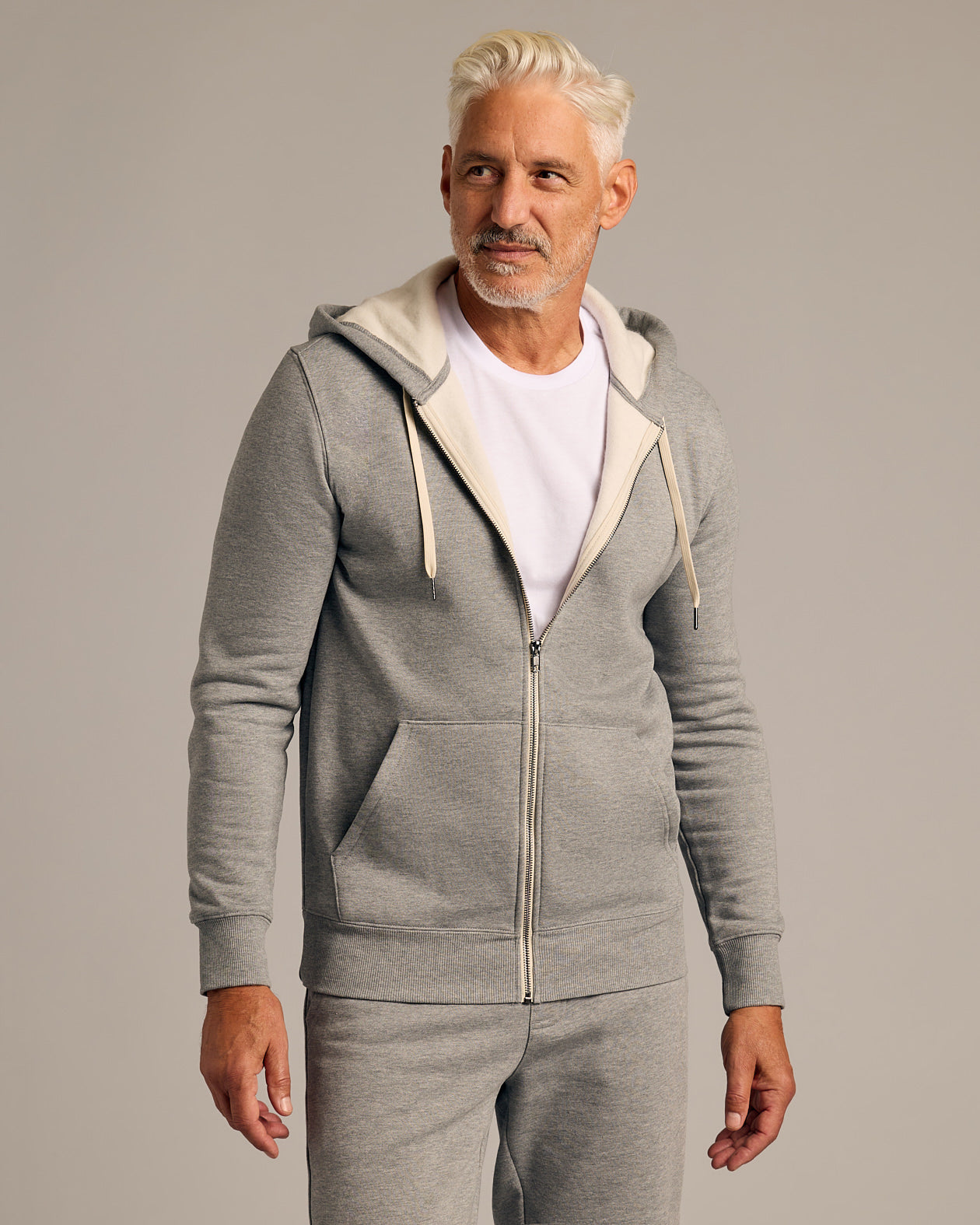 Model in 3 Day Travel Pack: light-gray zip-up hoodie, sweatpants.
