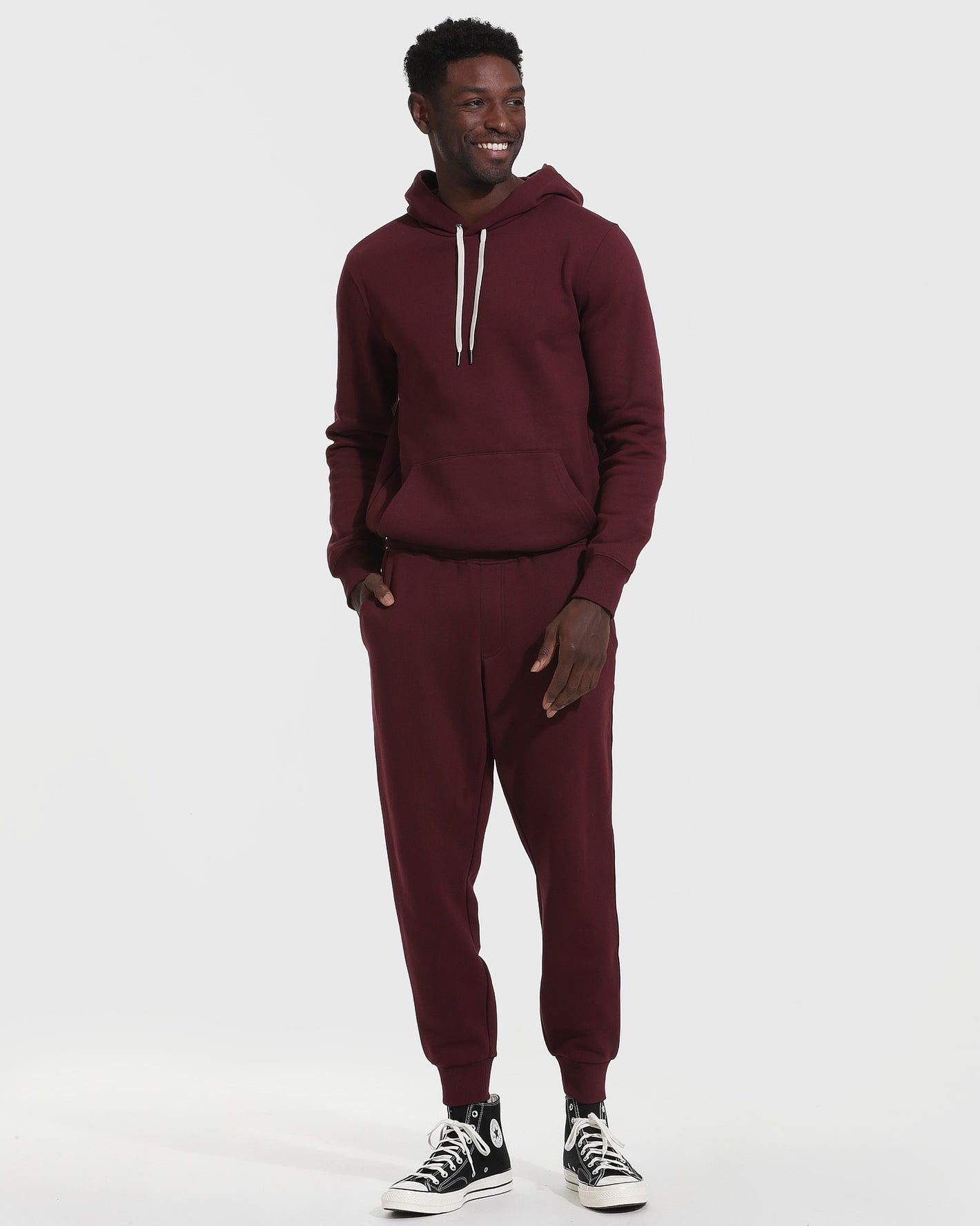 Man models Mahogany Fleece French Terry Pullover Hoodie with matching joggers.