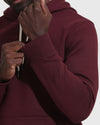 Adjusting the Mahogany Fleece French Terry Pullover Hoodie’s cuff and drawstrings.