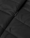 Black Puffer Jacket close-up with quilted baffles and zipper pull.