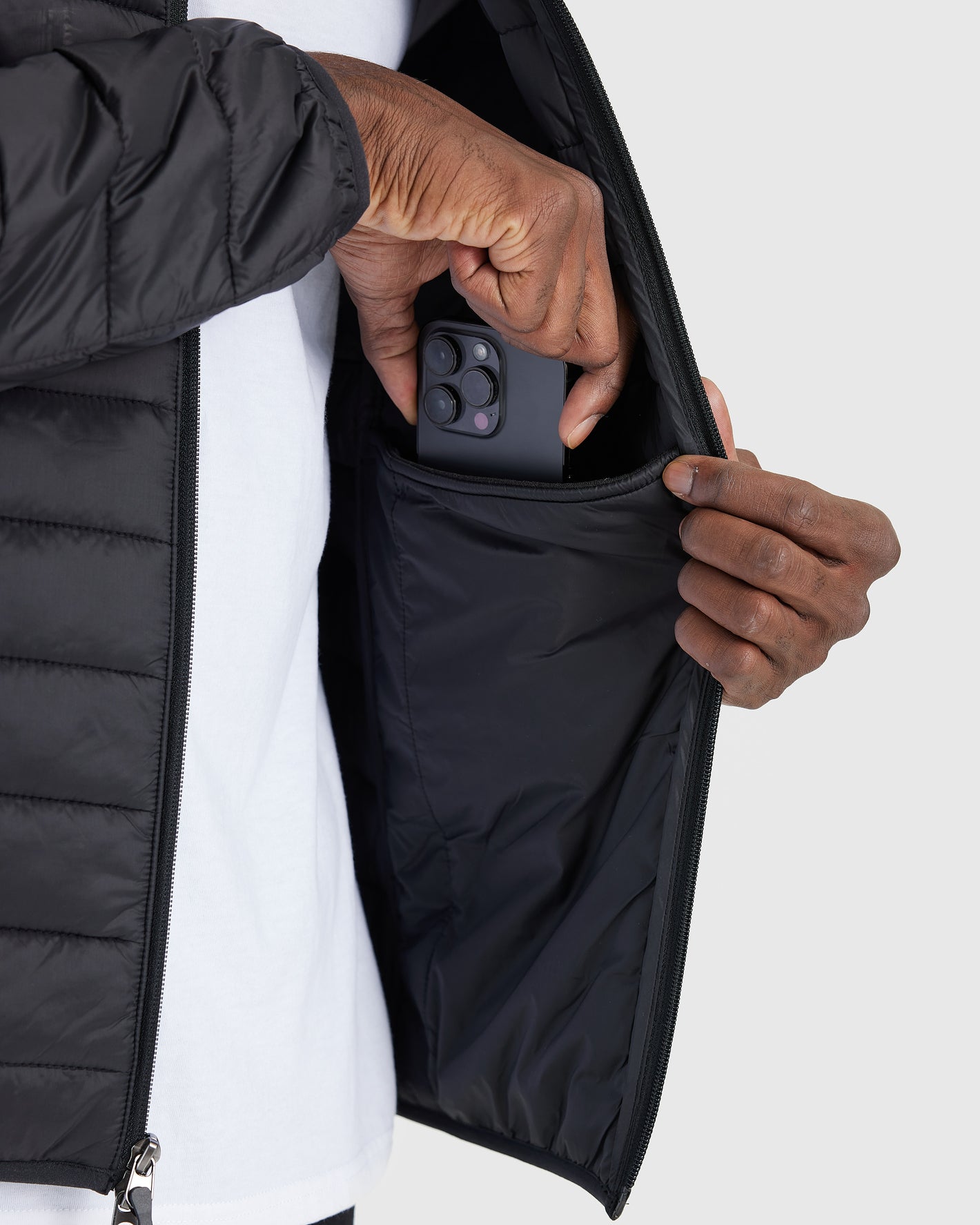 Black Puffer Jacket unzipped, revealing interior pocket with a smartphone.