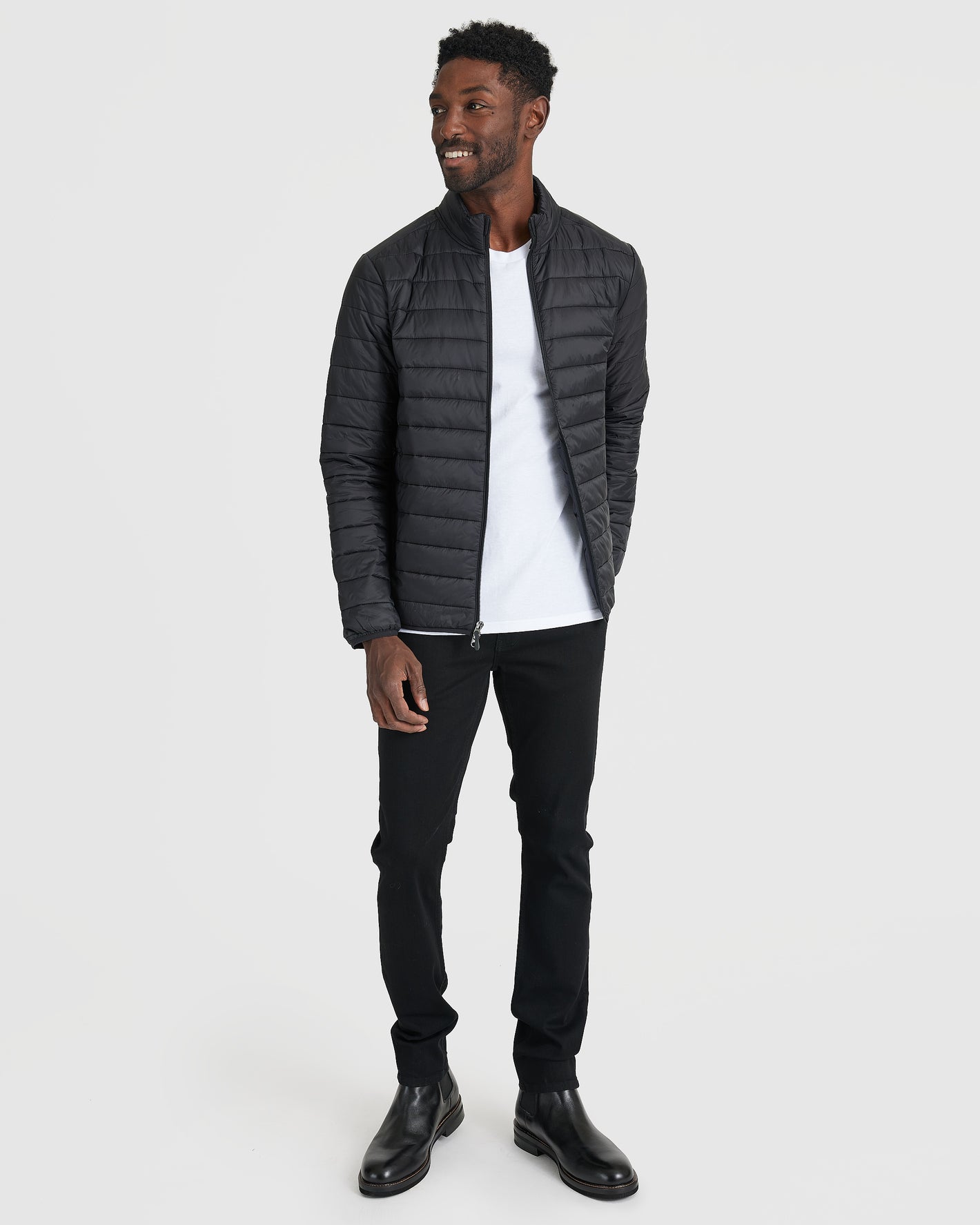 Black Puffer Jacket on model in slim black pants, boots.