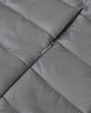 Gunmetal Puffer Jacket, close-up of grey quilted fabric with zipper.