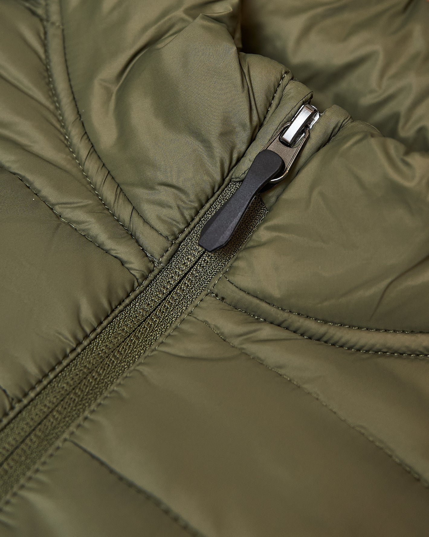 Military Green Puffer Jacket zipper detail with fabric pull tab.