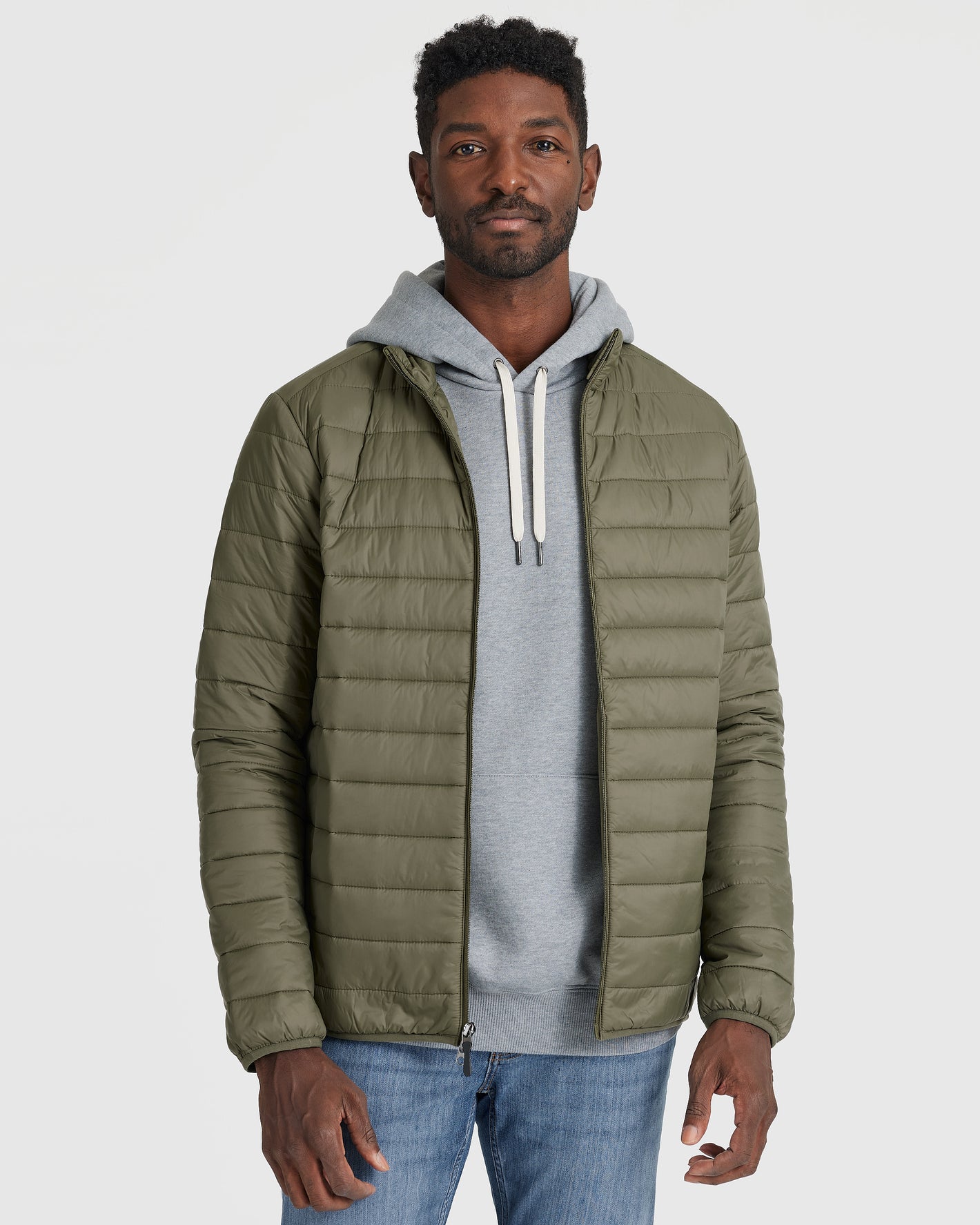 Man in slim-fit Military Green Puffer Jacket over grey hoodie.