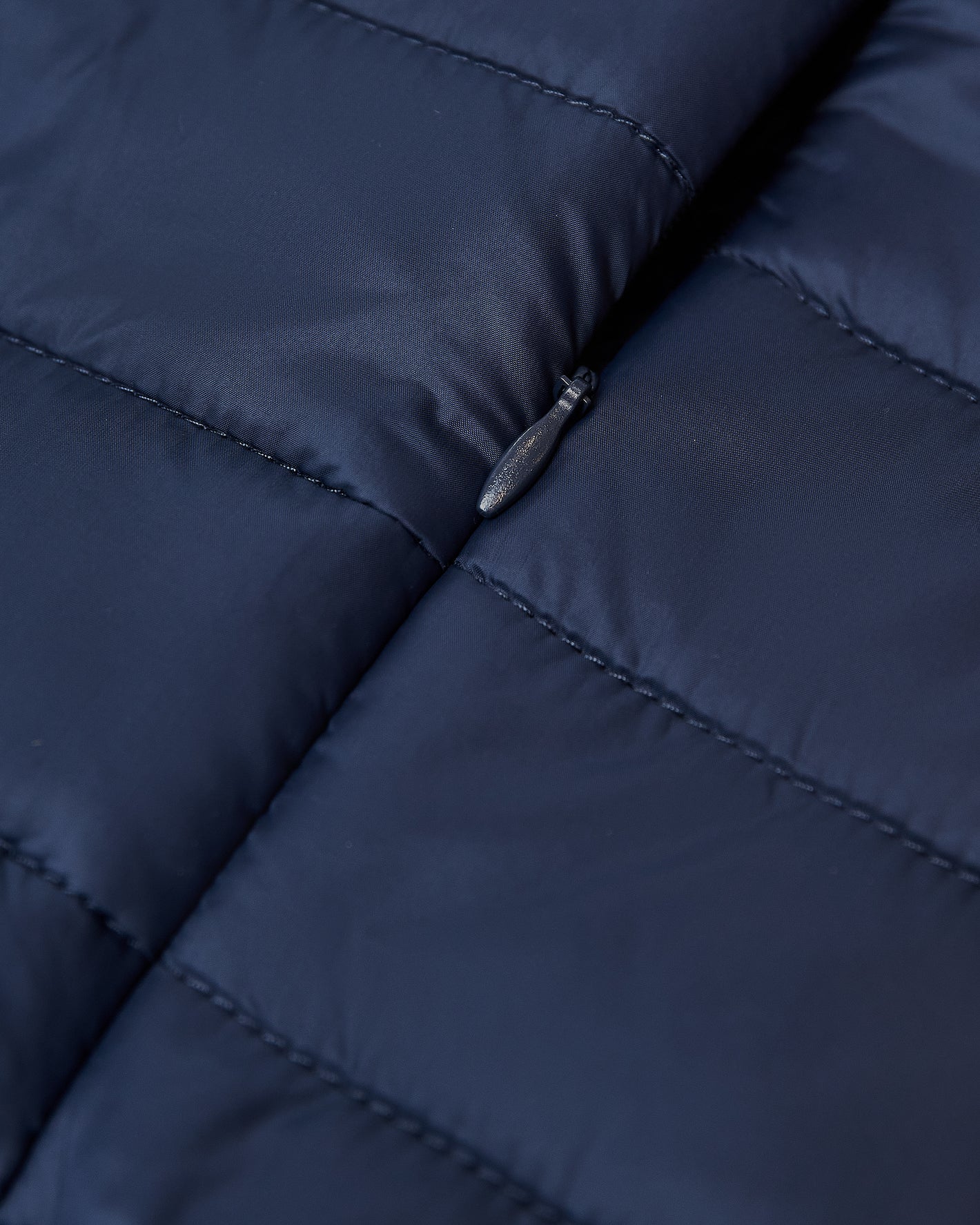 Navy Puffer Jacket with quilted design and visible zipper pull.