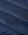 Navy Puffer Jacket close-up showing quilted, shiny fabric with horizontal stitching.