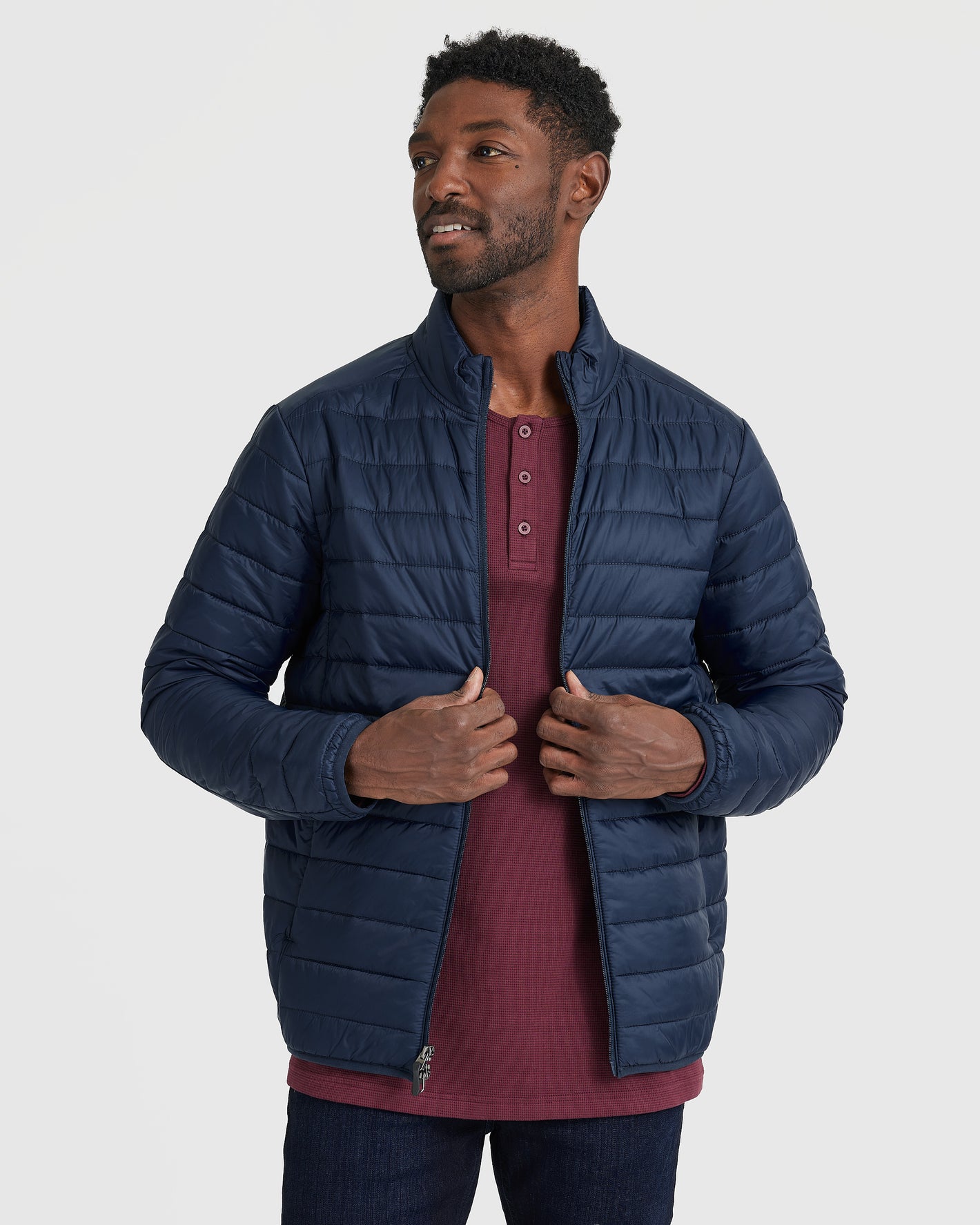 Male model in Navy Puffer Jacket, partially unzipped, against gray backdrop.
