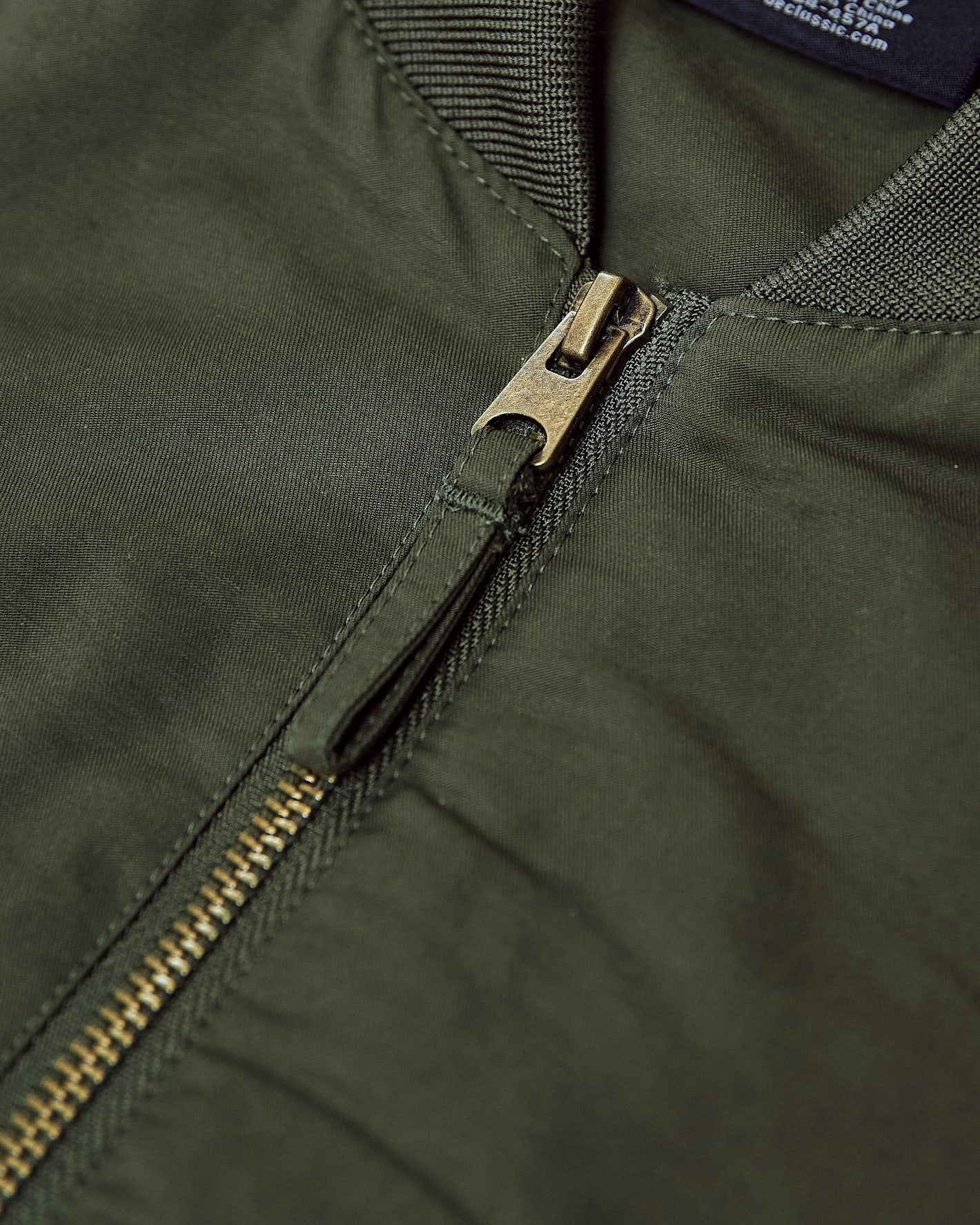 Army Green Bomber Jacket featuring brass-tone zipper and detailed collar stitching.