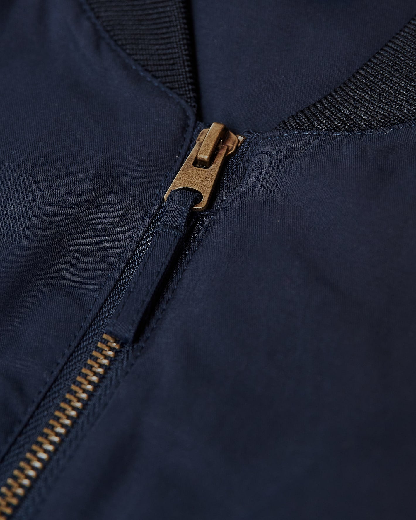 Navy Bomber Jacket with brass zipper and ribbed collar.