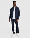 Man modeling Navy Bomber Jacket with jeans and sneakers.