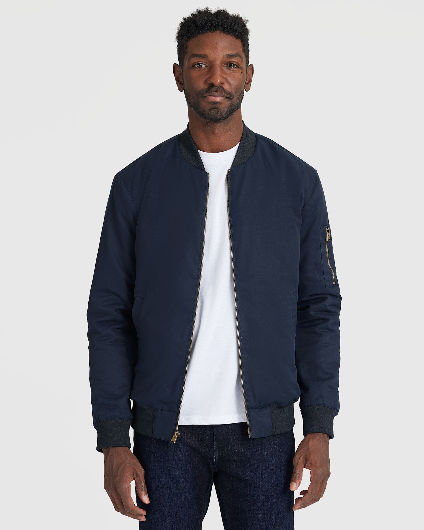 Navy Bomber Jacket on man, featuring zippered sleeve pocket.