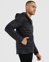 Black Hooded Puffer Jacket worn by man in profile, hand in pocket.