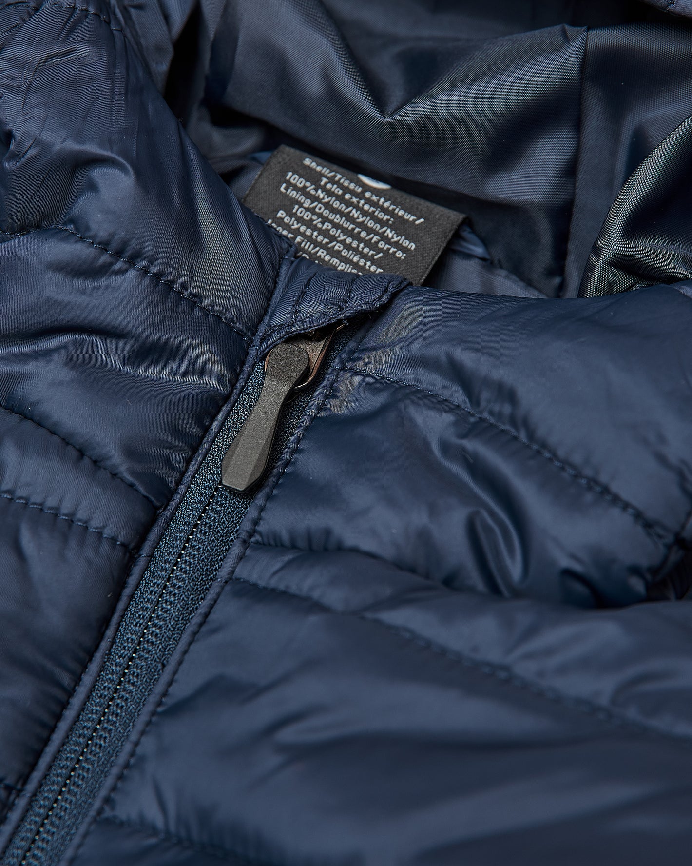 Navy Hooded Puffer Jacket with central zipper and interior label visible.