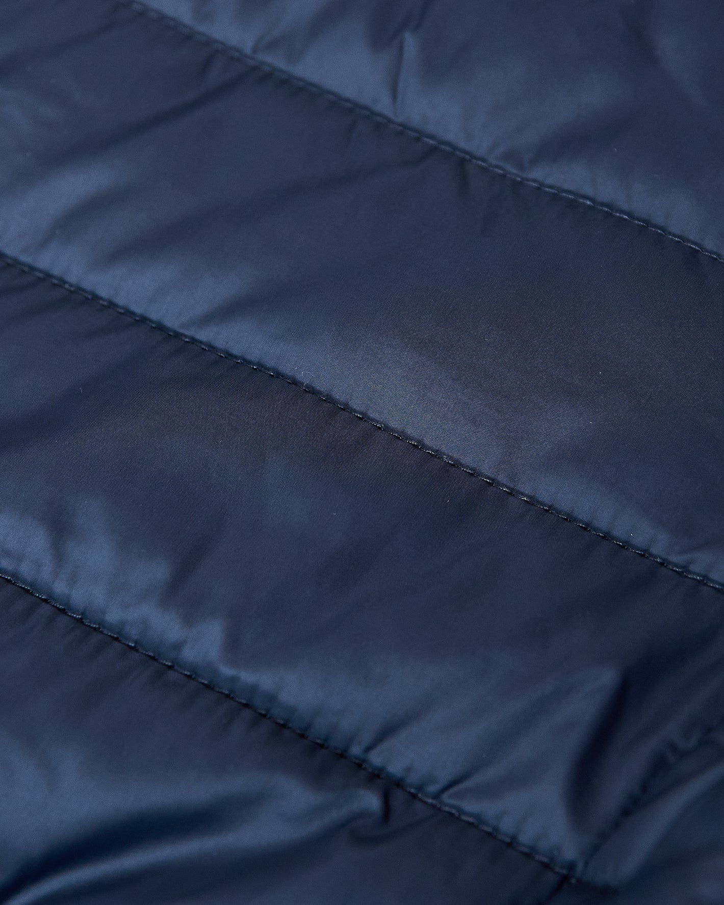 Navy Hooded Puffer Jacket with quilted fabric and horizontal stitching.
