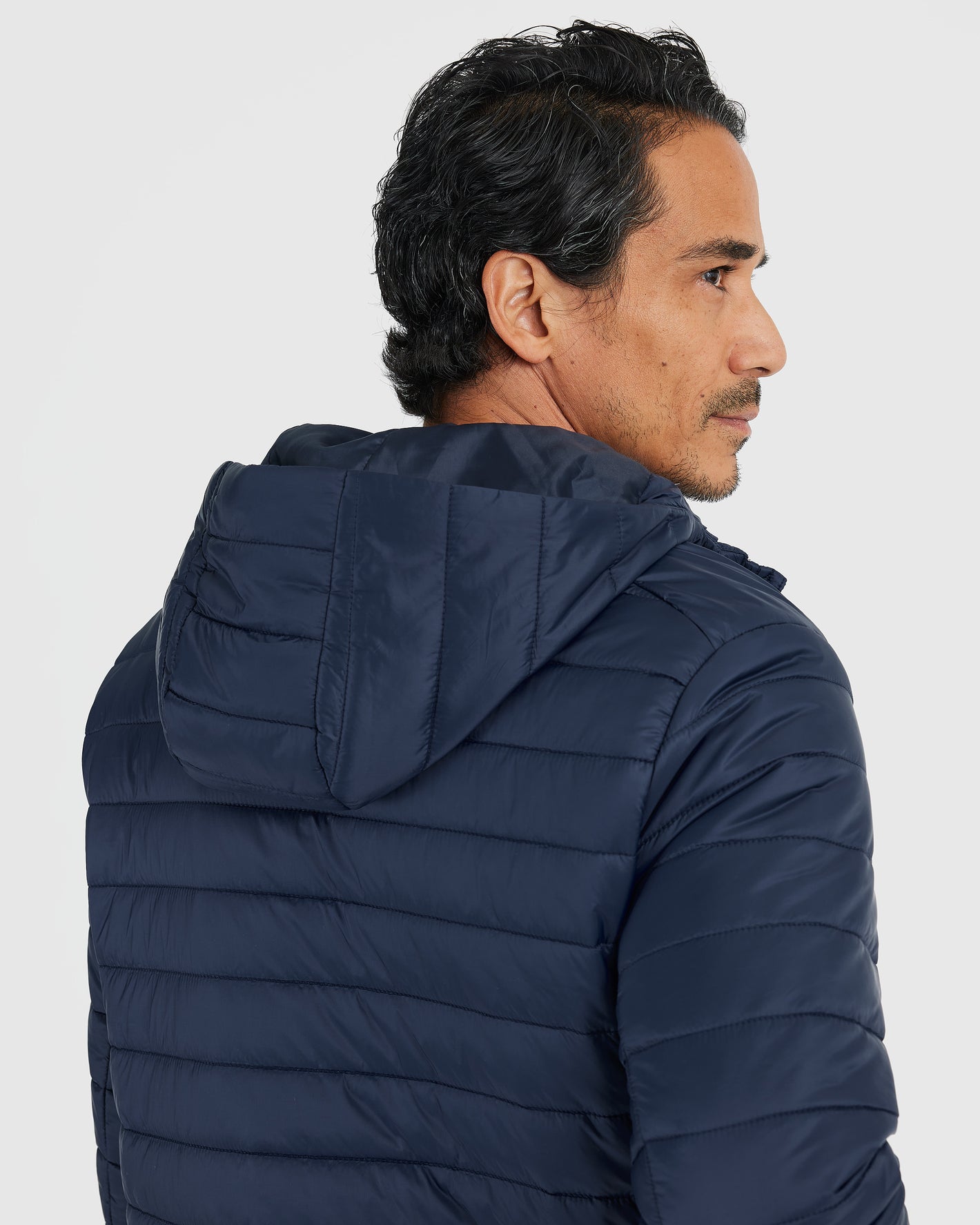 Man wearing Navy Hooded Puffer Jacket with quilted design and attached hood.