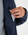 Navy Hooded Puffer Jacket with iPhone in chest pocket.