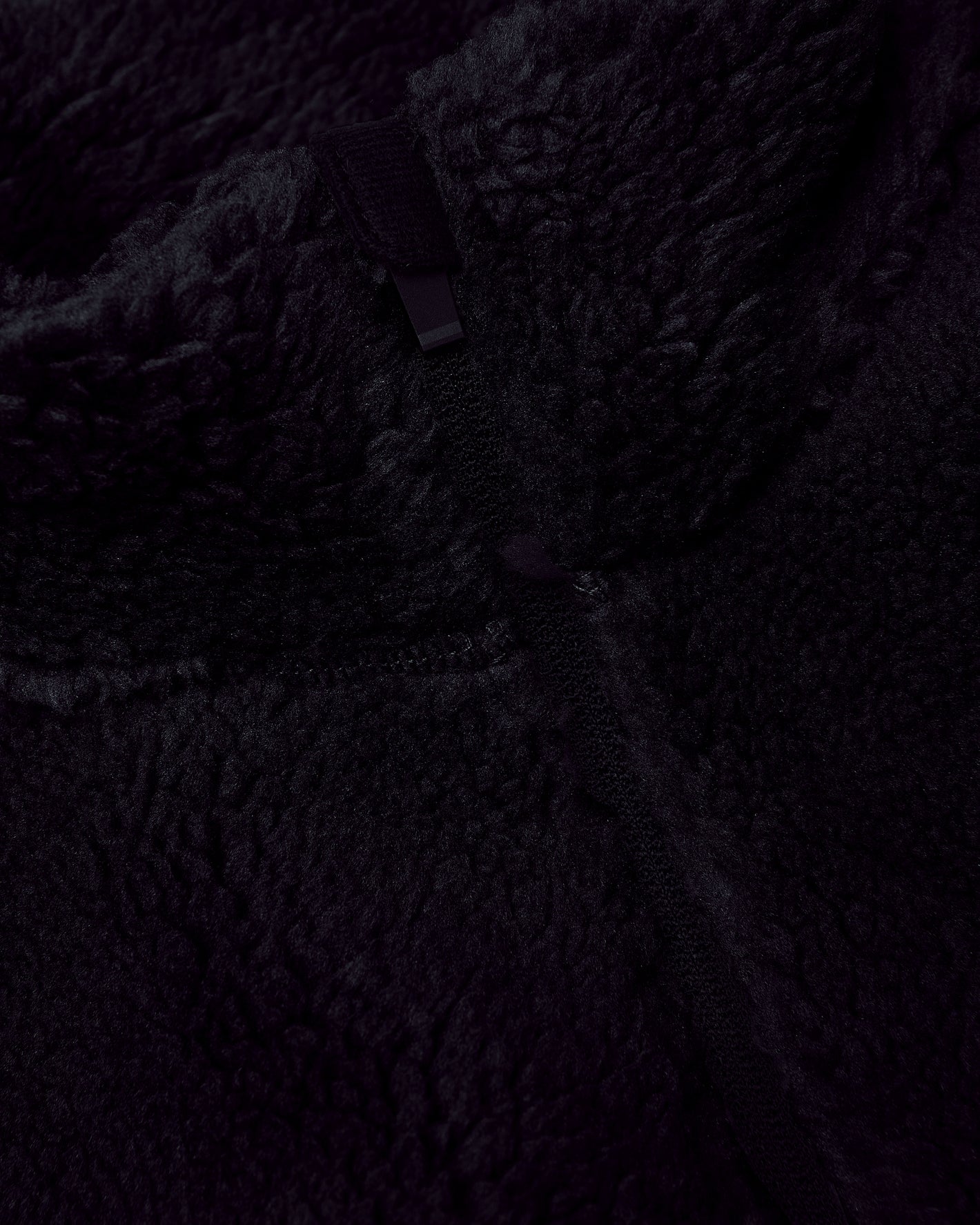 Black Sherpa Full Zip Jacket close-up showing soft fleece texture and zipper.