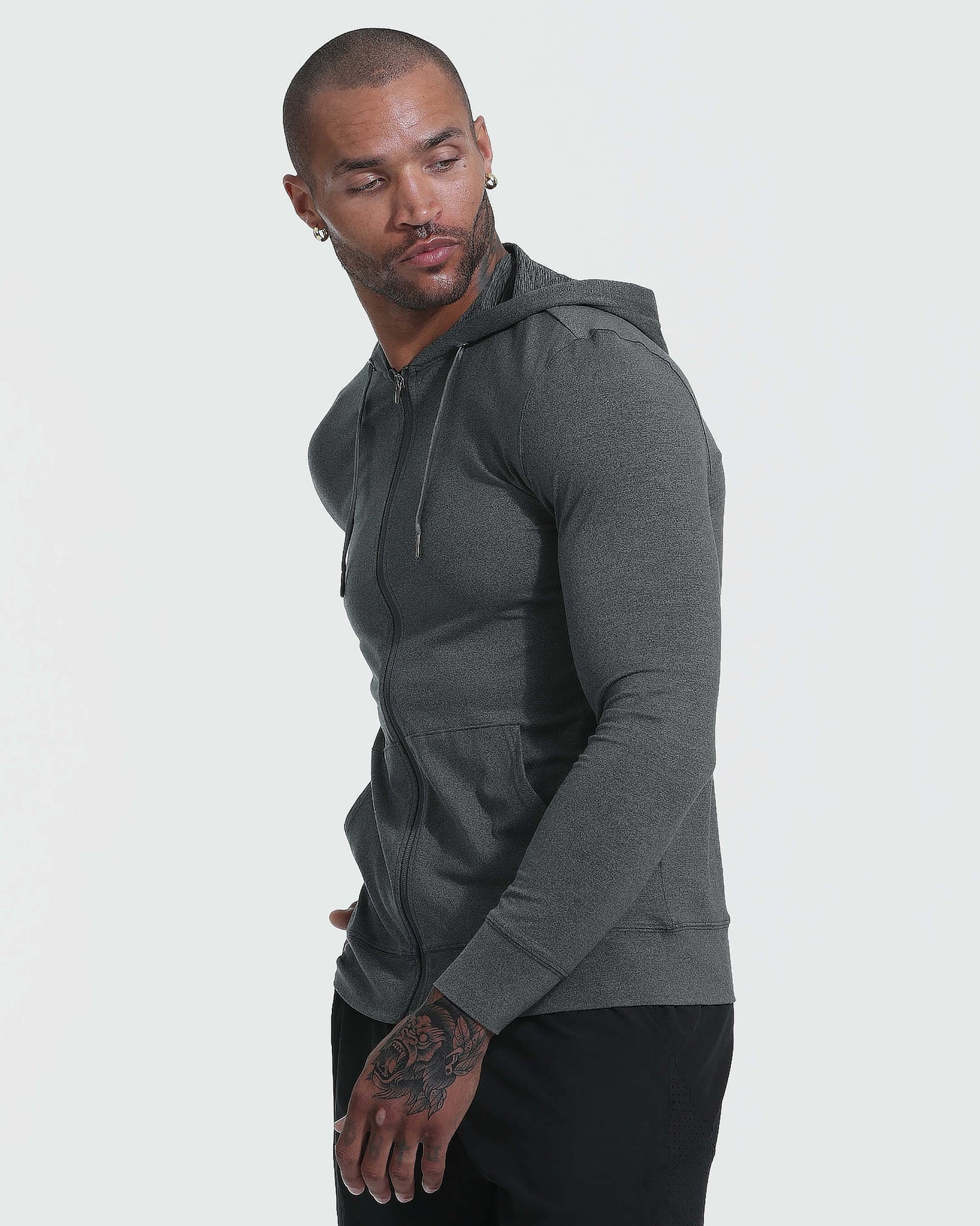 Model in Charcoal Heather Active Comfort Full Zip Hoodie, looking left.