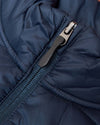 Navy Puffer Vest close-up of quilted fabric and front zipper.