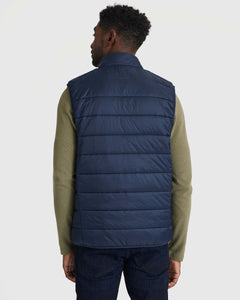 True ClassicNavy Puffer Vest layered over olive top and jeans, back view.