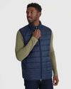 Man zipping Navy Puffer Vest over olive shirt.