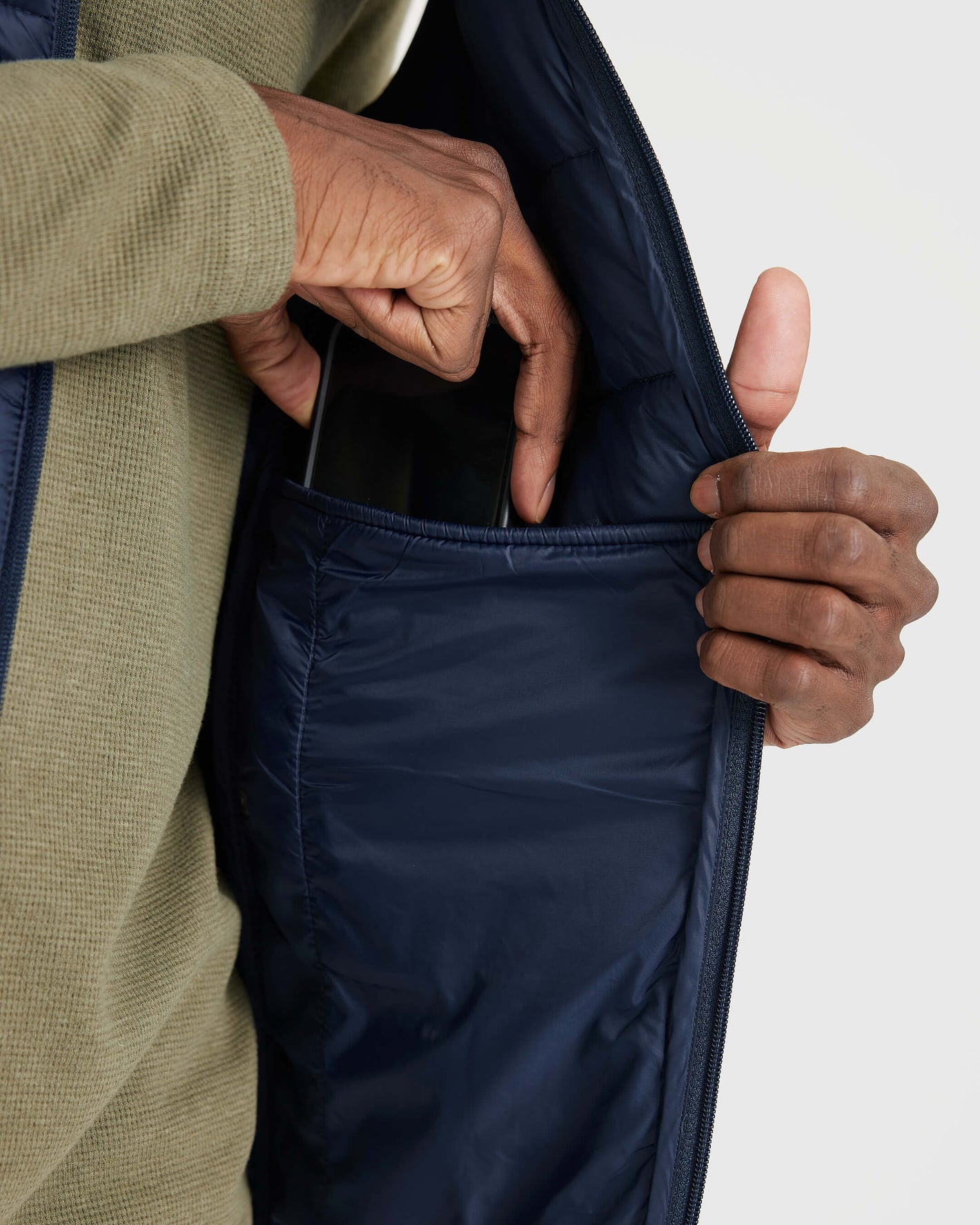 Navy Puffer Vest with large inner pocket for smartphone storage.