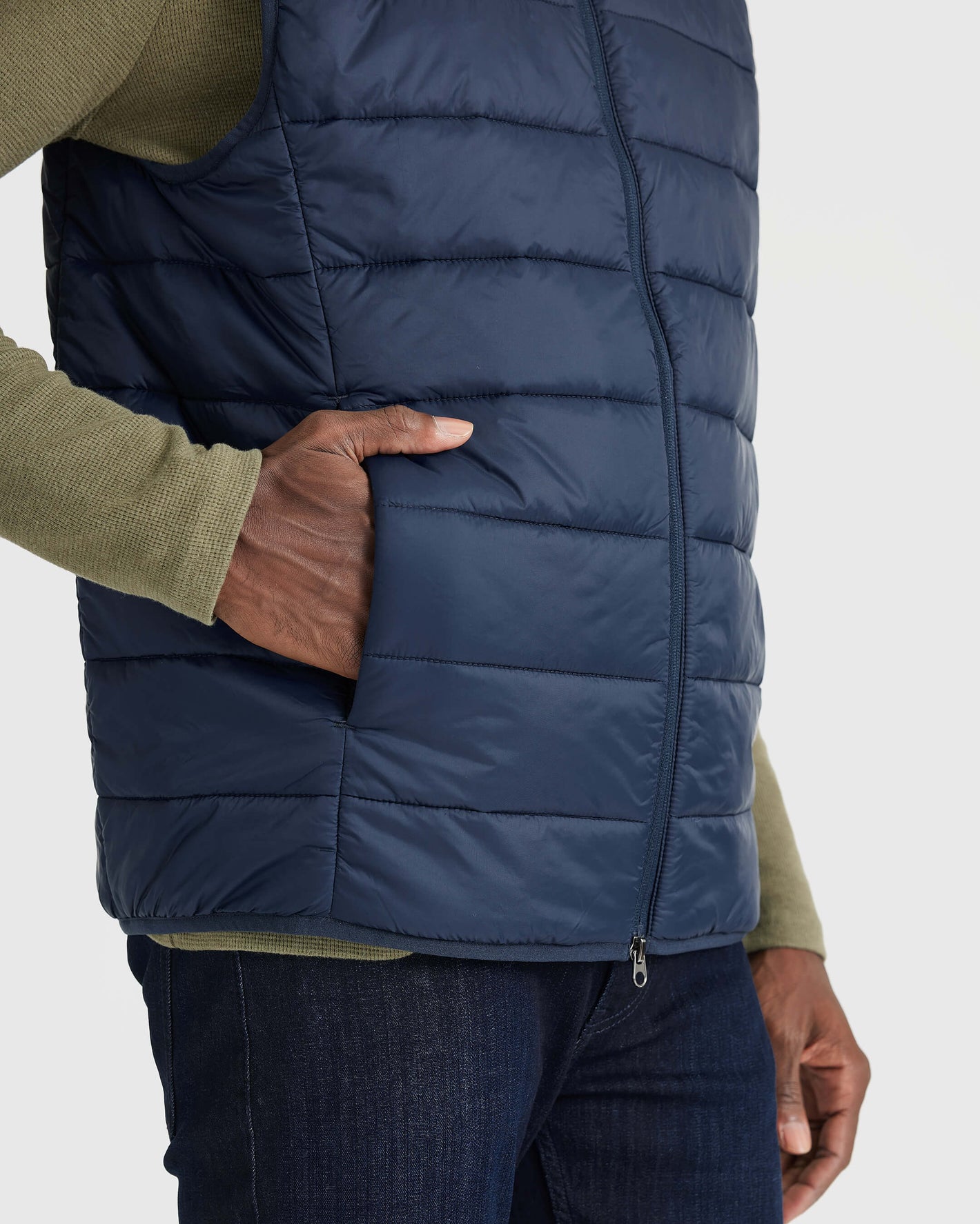 Person wearing Navy Puffer Vest with hand in pocket.