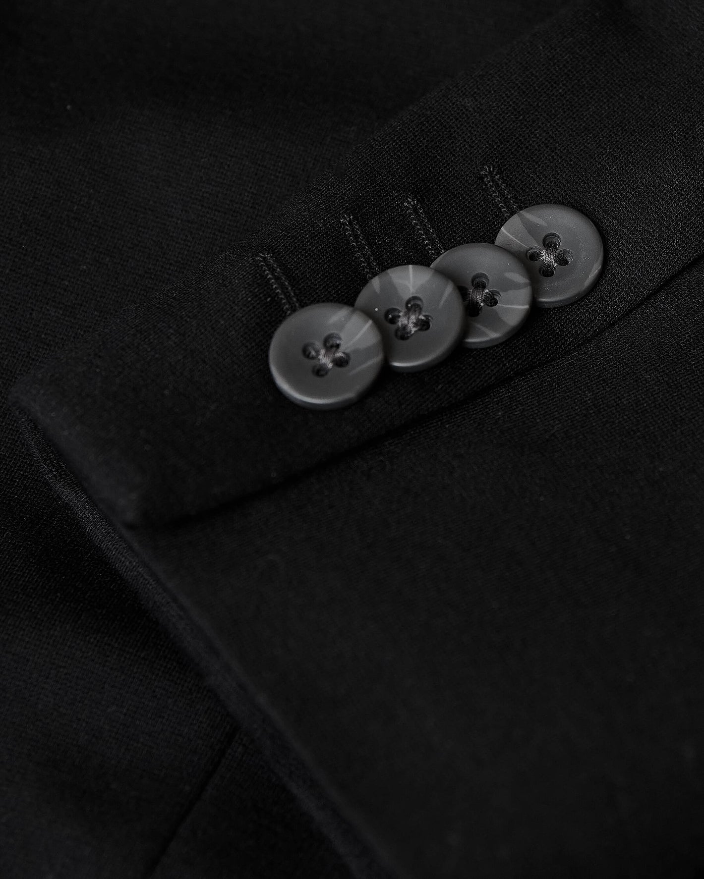 Black Comfort Knit Blazer sleeve close-up with four black buttons.