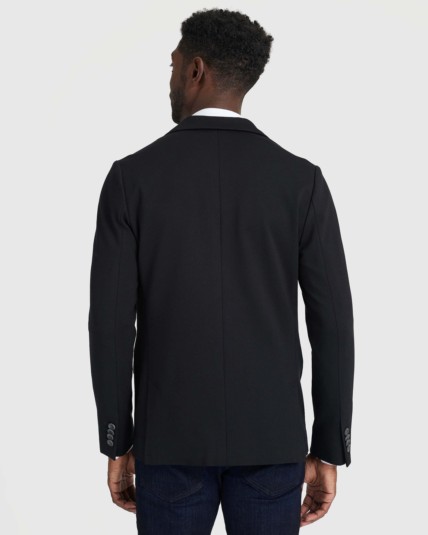 Back view of Black Comfort Knit Blazer over white-collared shirt.