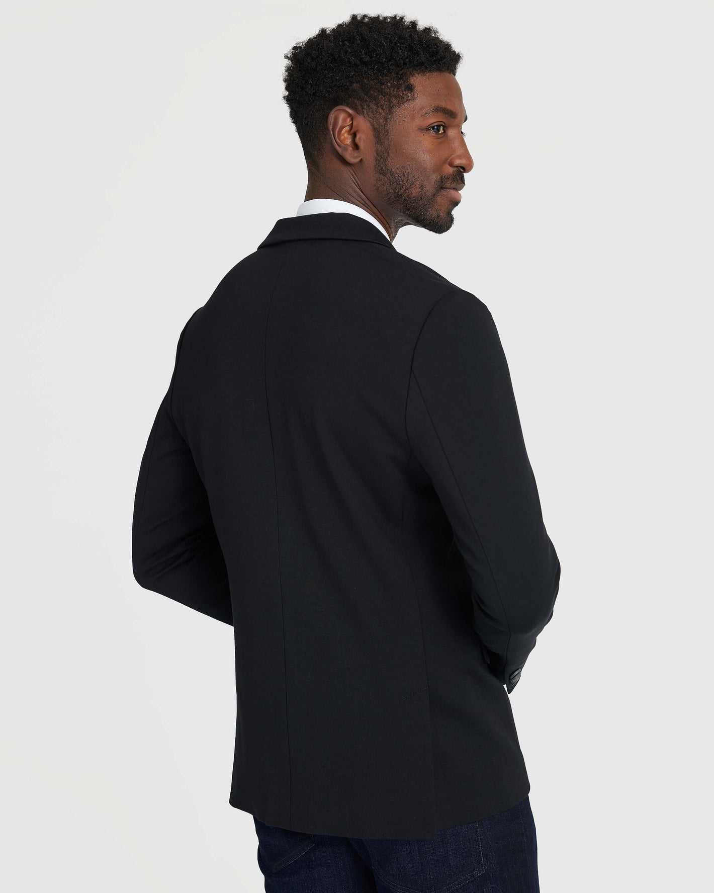 Black Comfort Knit Blazer on male model, turned away, showcasing fit.