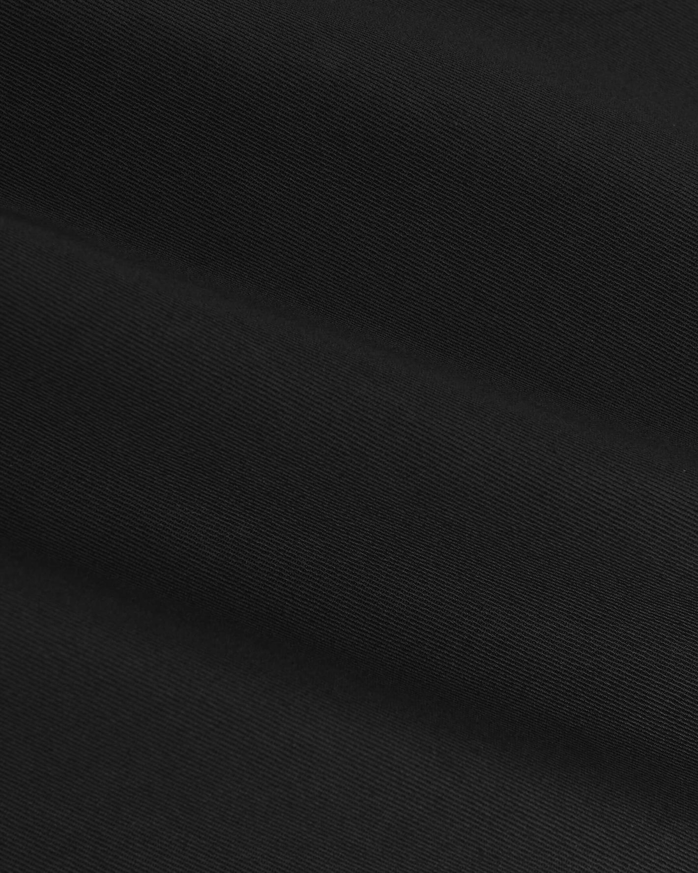 Black Coaches Jacket close-up, showcasing its diagonal twill weave and texture.