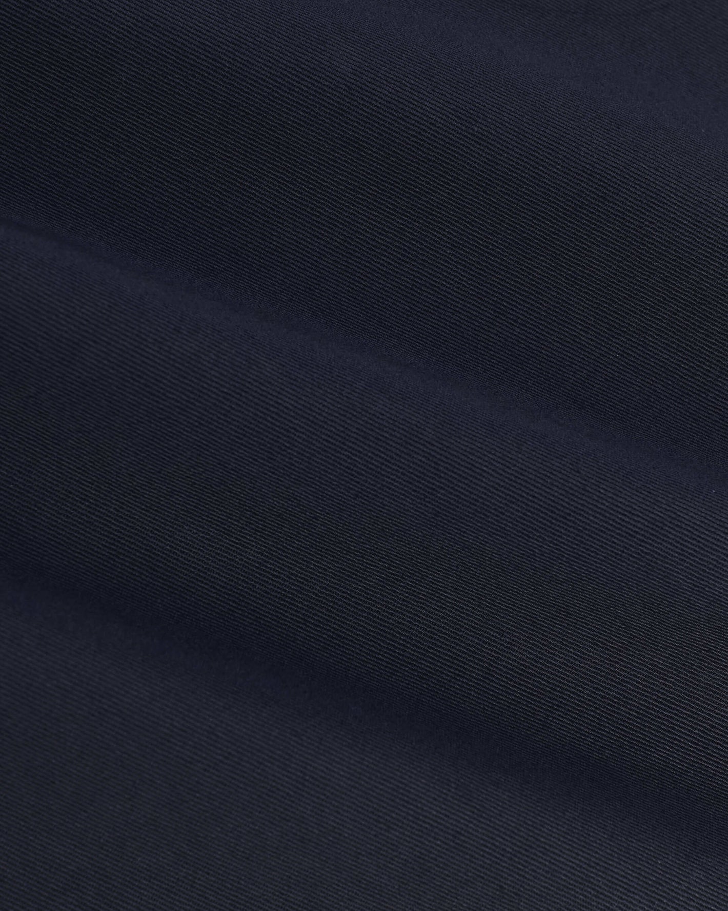 Navy Coaches Jacket's fine diagonal twill pattern, showcasing soft folds.